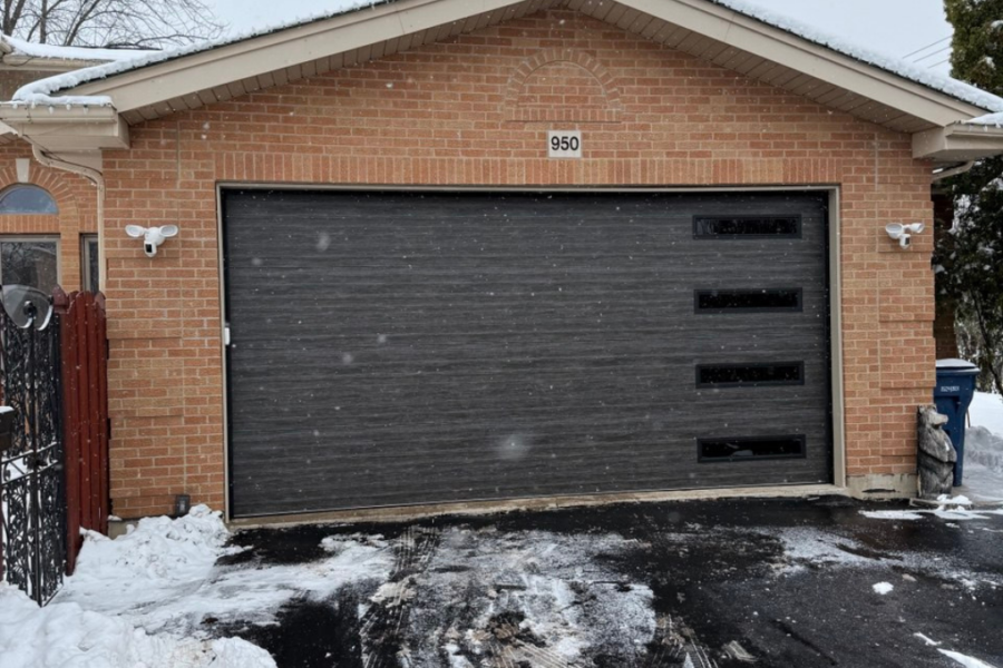 Modern black garage door featuring a sleek wood-grain finish Garage Door